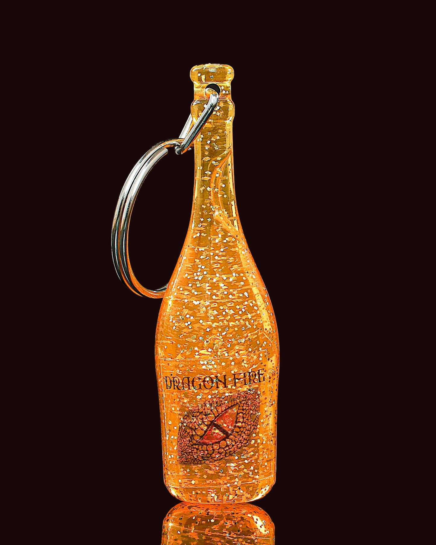 Dragon Fire bottle-shaped keychain with a reflective surface on a black background