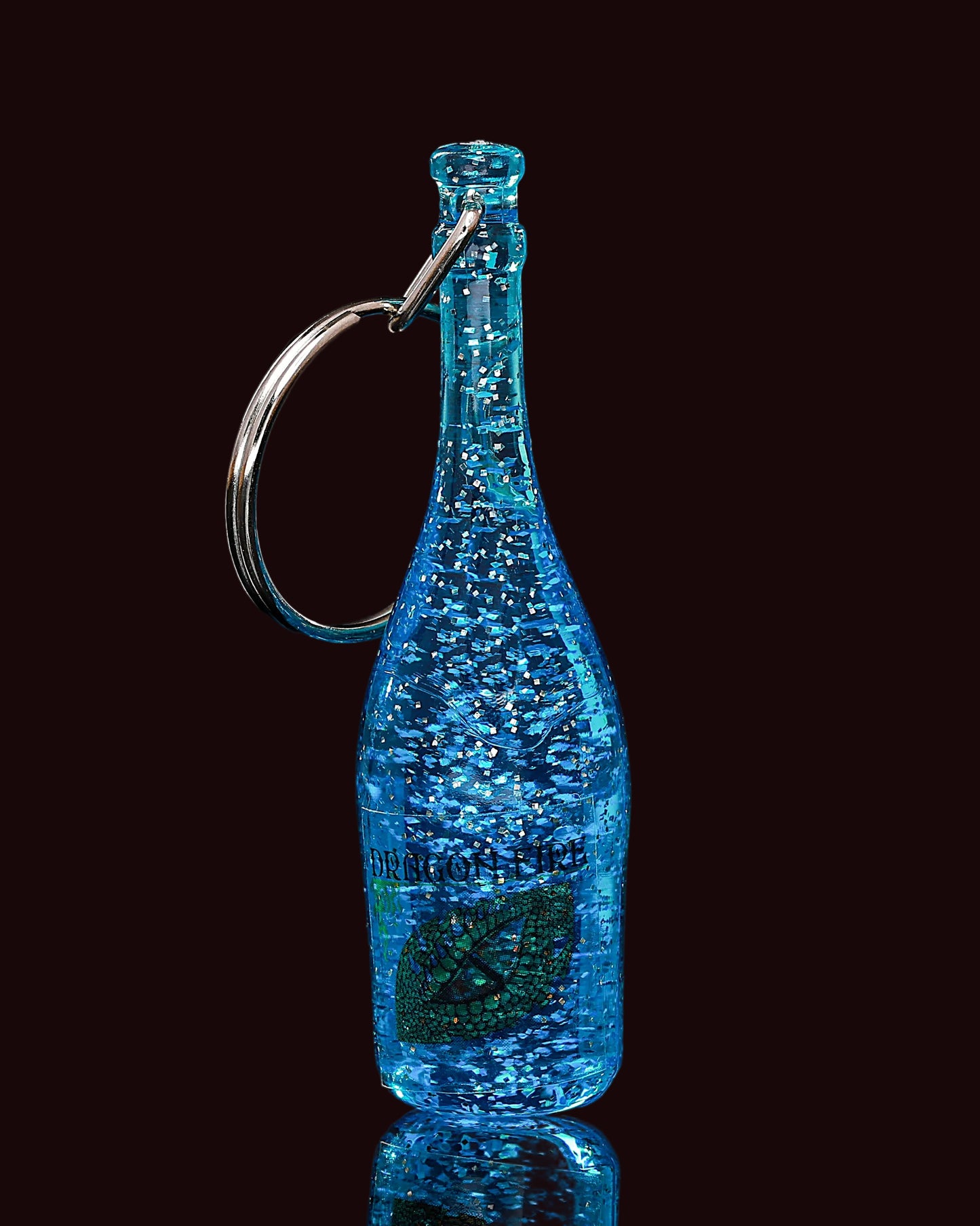 Blue bottle-shaped keychain with a metallic ring on a black background