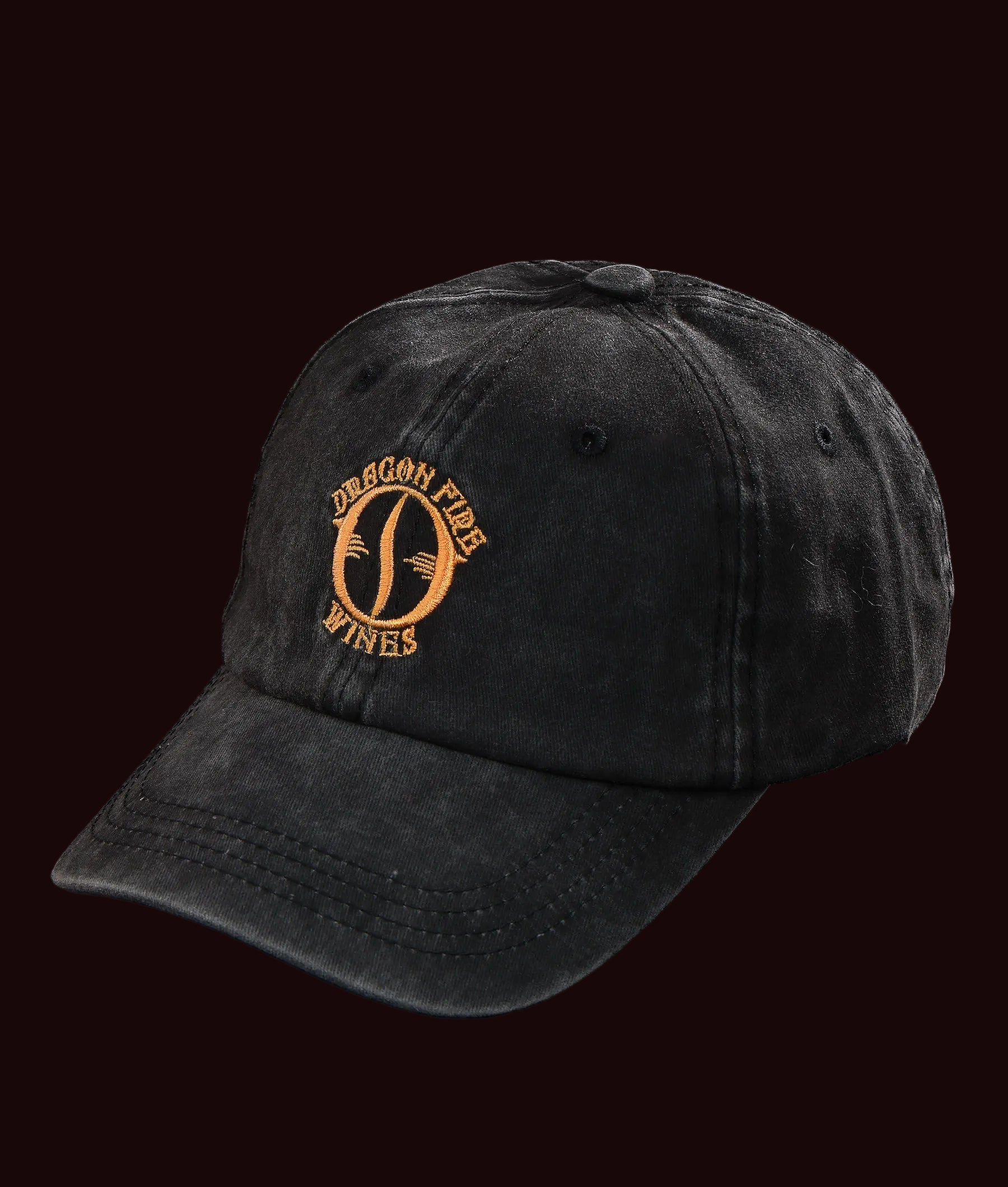 Black cap with gold embroidered logo on a black background