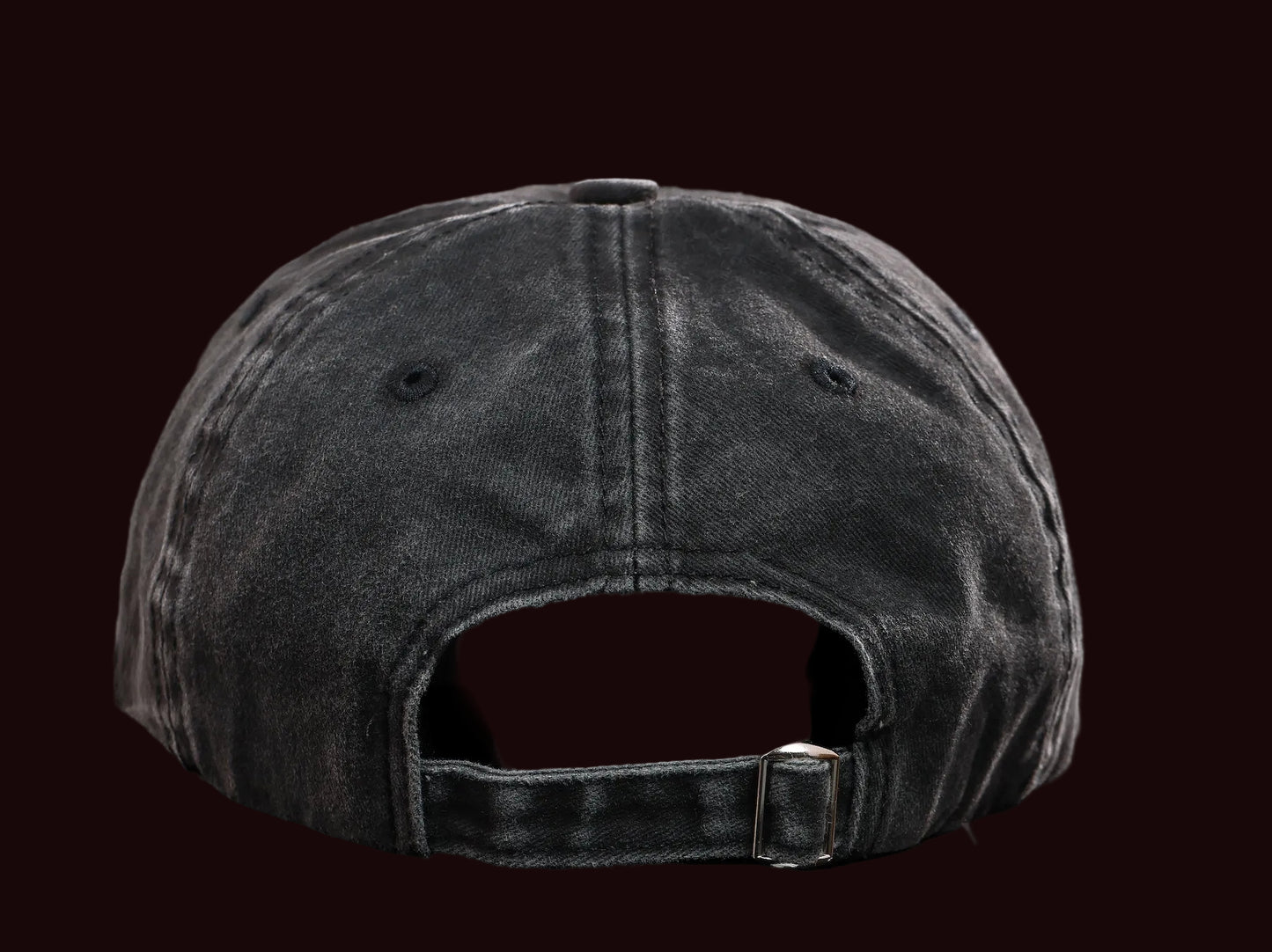 Back view of a black denim cap on a black background